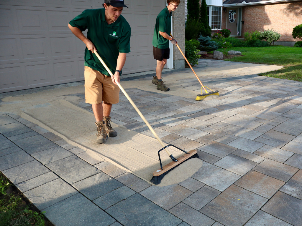 Team adding sand to interlock